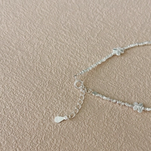 Macro detail of S925 sterling silver butterfly bracelet with irregular crushed silver beads