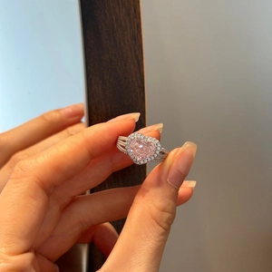 Macro shot of 925 silver heart ring with large pink gemstone and halo setting