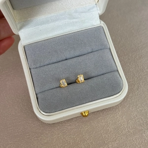 Close-up of baguette cut emerald zircon earrings in a velvet jewelry box