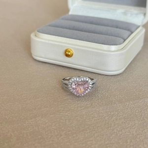 Macro view of a luxurious S925 silver heart-shaped pink gemstone ring with halo diamonds