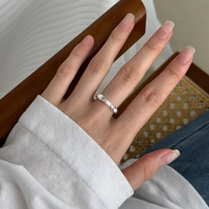 Detailed view of an irregular wavy S925 sterling silver ring on a model hand