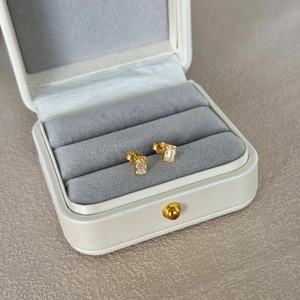 Detailed close-up of S925 silver gold-plated square emerald cut zircon earrings in a box