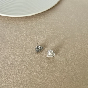 Close-up of S925 sterling silver heart studs with zircon paving and brushed texture finish