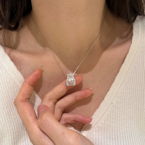 Detail of S925 silver necklace with square pink stone pendant on a female model