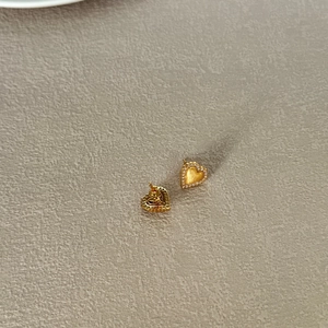 Detailed view of S925 silver heart stud earrings with brushed gold and pavé zircon stones