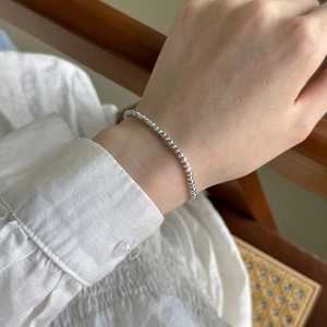 Gros plan d'un bracelet en argent S925 avec perles facettées sur un poignet de femme