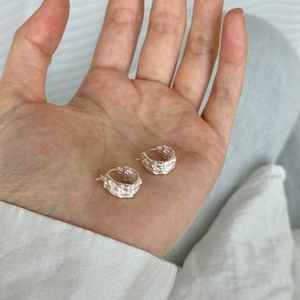 S925 sterling silver hoop earrings with unique lava rock texture on a palm
