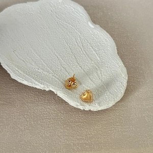 Macro shot of S925 sterling silver heart earrings with zircon inlay and brushed gold finish