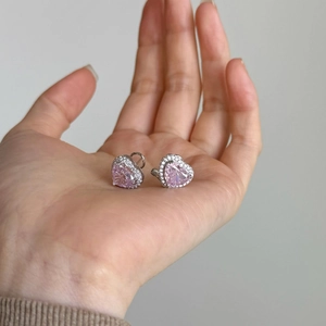 Macro shot of silver heart earrings with pink ice flower cut stones and zircon halo