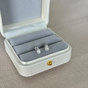 Macro detail of pear-cut emerald cubic zirconia studs on a velvet jewelry display box