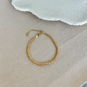 Détail du bracelet en argent S925 avec perles dorées et gravure de qualité métal