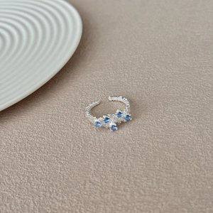 Detailed view of S925 silver ring with blue zircons and textured granular finish