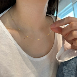 Delicate S925 sterling silver necklace with gold cylindrical accents worn by a model