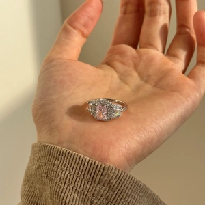 Macro detail of S925 silver halo ring with large radiant cut pink stone and side diamonds