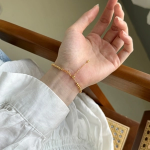 Bracelet élégant en perles d'argent plaqué or au poignet avec chaînette d'extension