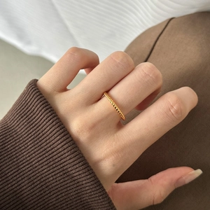 Minimalist gold twisted rope ring on finger for a stylish and elegant stacked look