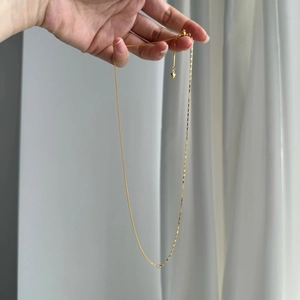 Detailed view of mixed link gold silver necklace with heart pendant and adjustable bead clasp