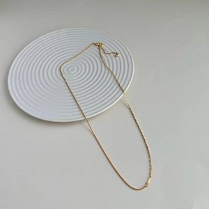 Gold-plated mixed chain necklace featuring box and rectangular links with heart charm