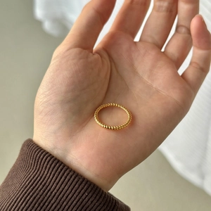 Minimalist S925 sterling silver twisted rope ring in gold finish worn on palm