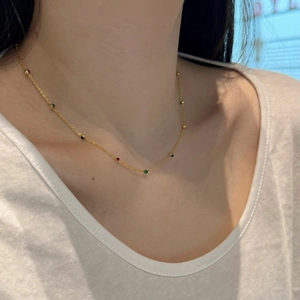 Detail of S925 silver necklace with colored zircons worn on female collarbone