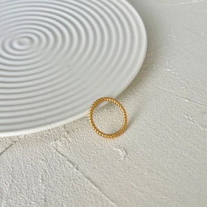 Minimalist S925 sterling silver ring with golden braided twist texture on a stone background