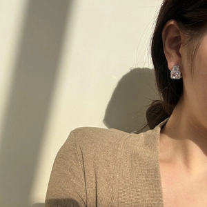 Close-up of elegant S925 silver stud earrings with pink cushion-cut stone on model