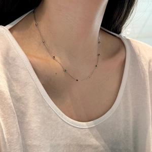 Detail of S925 silver necklace featuring colorful zircon beads on a woman's collarbone