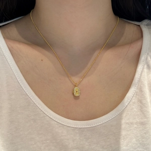 Détail d'un collier en argent S925 doré avec pendentif pierre rouge et oxydes de zirconium