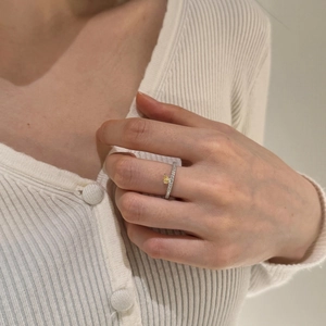 Gros plan d'une bague en argent S925 avec pierre jaune en goutte et pavé de diamants