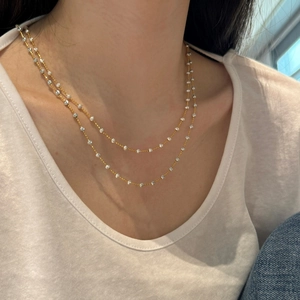 Detail of bohemian gold layered necklace with sparkling silver faceted beads on a model