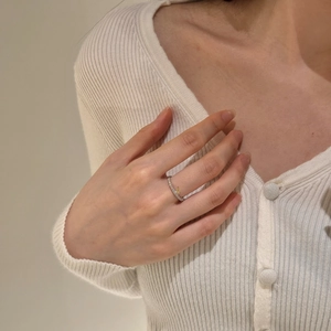 Détail d'une bague en argent S925 avec pierre jaune en forme de goutte sur le doigt