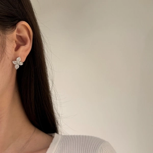 Close-up of sparkling butterfly silver earrings with pave-set stones worn by a model