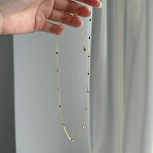 Close-up of golden S925 sterling silver necklace featuring delicate multi-color zircons