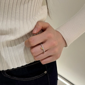Gros plan d'une bague en argent S925 avec une pierre jaune taille poire sur le doigt