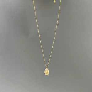 Détail du pendentif ovale en argent S925 plaqué or avec pierre rouge et zircons brillants