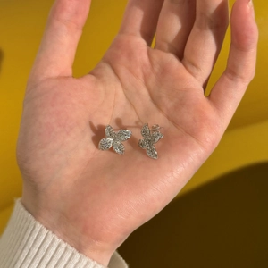 Detailed close-up of sparkling silver butterfly stud earrings with micro-pave crystals