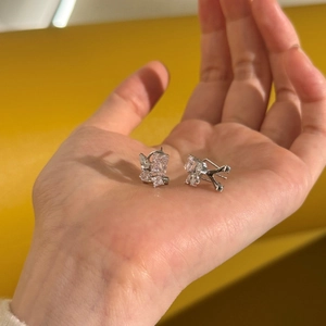 Detailed view of S925 sterling silver stud earrings with radiant ice-cut crystals on hand