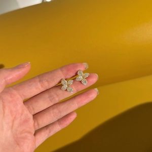 Macro shot of gold butterfly earrings with micro-set shimmering cubic zirconia crystals