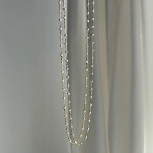 Detail of two-tone S925 silver necklace featuring gold chain and silver faceted beads