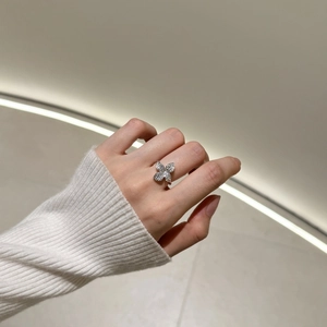 Macro shot of a floral silver ring with pavé crystals worn on a finger for a chic look