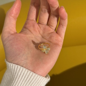 Macro view of adjustable gold-plated ring with crystal-encrusted four-leaf clover detail