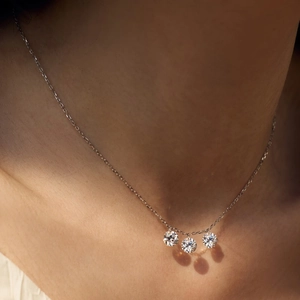 Close-up of elegant S925 sterling silver necklace with three sparkling round pendants