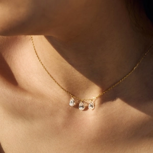 Detail of S925 silver necklace with three teardrop zircon pendants on model's neck