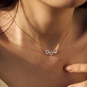 Close-up of elegant gold S925 sterling silver necklace featuring three sparkling zircons