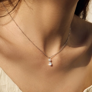 Elegant S925 silver necklace featuring round and pear-shaped zircon stones on a model