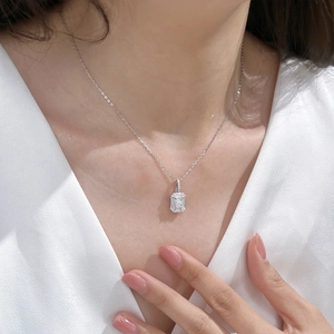 Detail of S925 sterling silver necklace with emerald-cut zirconia pendant on model