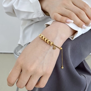 Elegante bracciale in oro con moneta, cristalli pavé e chiusura a scorrimento regolabile