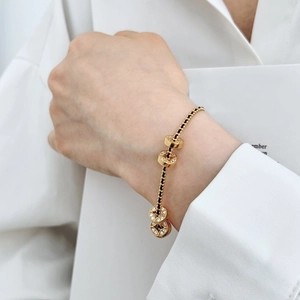 Dettaglio del bracciale in argento S925 placcato oro con cordino nero e monete