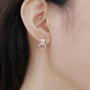 Close-up of S925 silver double heart earrings with white zircon stones on model