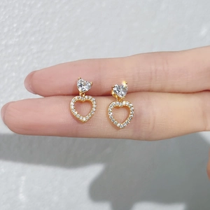 Close-up of S925 sterling silver heart earrings with sparkling white zircons in gold finish